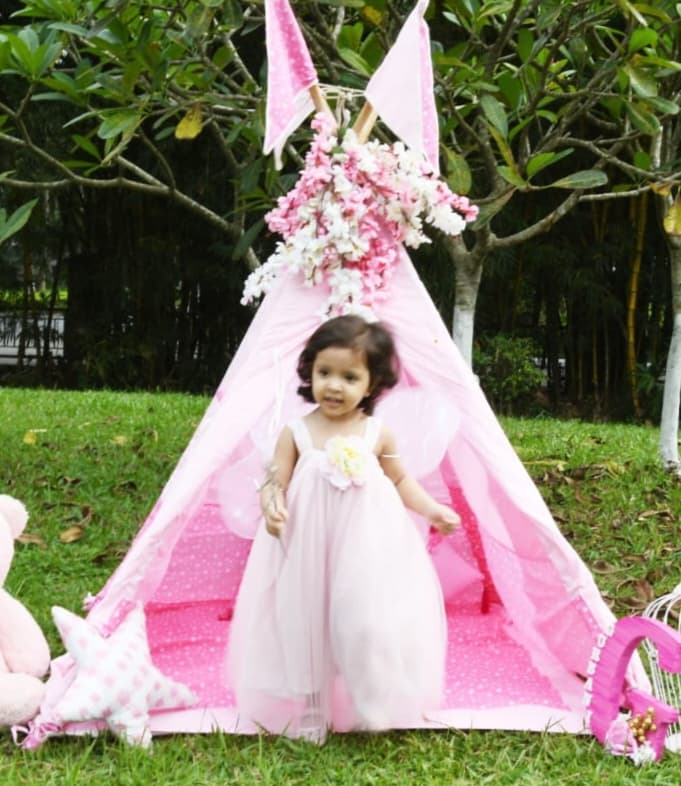 pink teepee tent set up in garden for baby photoshoot